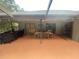 Outdoor patio featuring a dining table set, barbecue grill, and views of the green backyard at 12090 Stoneville Ct, Spring Hill, FL 34609