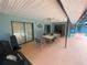 Covered patio area with an outdoor dining set, providing a comfortable space for outdoor gatherings at 12090 Stoneville Ct, Spring Hill, FL 34609