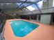 In-ground pool within a screened enclosure, adjacent to the house with visible outdoor lounging and dining at 12090 Stoneville Ct, Spring Hill, FL 34609