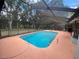 Beautiful in-ground pool surrounded by a screened enclosure, providing a relaxing outdoor space at 12090 Stoneville Ct, Spring Hill, FL 34609