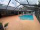 Backyard pool area featuring an enclosed in-ground pool with an outdoor dining set visible in the background at 12090 Stoneville Ct, Spring Hill, FL 34609