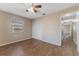 Bedroom featuring wood-look flooring, neutral walls, ceiling fan, window, closet, and doorway leading to hallway at 12155 Environmental Dr # 8, New Port Richey, FL 34654