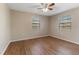 Bedroom featuring wood-look flooring, neutral walls, ceiling fan, and two windows providing ample natural light at 12155 Environmental Dr # 8, New Port Richey, FL 34654