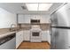Bright kitchen features white cabinets, stainless steel appliances, and granite countertops at 12155 Environmental Dr # 8, New Port Richey, FL 34654