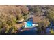 Aerial view of community pool, shuffleboard court, pond, and recreation center at 12155 Environmental Dr # 8, New Port Richey, FL 34654