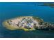 Aerial view of a sandy peninsula surrounded by clear blue water, featuring trees and parking at 124 Athens St, Tarpon Springs, FL 34689