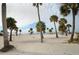Scenic beach view with white sands, clear skies, and numerous palm trees providing shade at 124 Athens St, Tarpon Springs, FL 34689