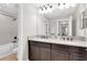 Bright bathroom featuring a double vanity with granite countertops, large mirror, and shower at 12420 Rangeland Blvd, Odessa, FL 33556