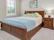 Comfortable bedroom with a wooden bed frame, matching nightstand, and a bright window at 12420 Rangeland Blvd, Odessa, FL 33556