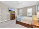 Charming bedroom featuring a wooden dresser, mounted TV, and bright natural light at 12420 Rangeland Blvd, Odessa, FL 33556