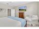 Serene bedroom with a cozy armchair, wooden dresser, and mounted television at 12420 Rangeland Blvd, Odessa, FL 33556