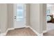 Entryway with a glass paneled front door and stylish wood-look flooring, leading to the bedroom at 12420 Rangeland Blvd, Odessa, FL 33556