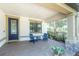Cozy covered front porch with brick pavers, comfortable seating, and views of the surrounding landscape at 12420 Rangeland Blvd, Odessa, FL 33556