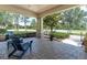 Inviting covered front porch featuring classic pavers, stylish seating, and a serene outdoor view at 12420 Rangeland Blvd, Odessa, FL 33556