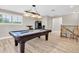 Spacious game room with billiard table, vintage arcade machine, and natural light at 12420 Rangeland Blvd, Odessa, FL 33556