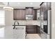Close up of the kitchen featuring stainless steel appliances, dark cabinets, and a neutral backsplash at 12420 Rangeland Blvd, Odessa, FL 33556