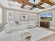 Bright living room with wood beam ceiling, tray ceiling, and comfortable seating arrangement at 12420 Rangeland Blvd, Odessa, FL 33556