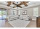Bright, airy living room featuring wood beam ceiling, a comfortable sectional, and backyard views at 12420 Rangeland Blvd, Odessa, FL 33556