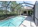 Refreshing screened-in pool with brick patio and inviting seating area on the covered lanai at 12420 Rangeland Blvd, Odessa, FL 33556