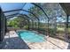 Sparkling screened-in pool area with brick patio, waterfall feature, and lush greenery at 12420 Rangeland Blvd, Odessa, FL 33556