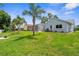 Lush green backyard with palm trees and a screened-in pool area, perfect for relaxing and entertaining at 1245 Overland Dr, Spring Hill, FL 34608