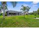 Expansive backyard with lush green lawn and a screened-in lanai, perfect for outdoor living at 1245 Overland Dr, Spring Hill, FL 34608