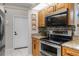 Stainless steel appliances, oak cabinets, and granite countertops with modern tile backsplash at 1245 Overland Dr, Spring Hill, FL 34608