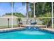Inviting pool with mermaid statue and tiled accents, surrounded by palm trees in a screened enclosure at 1245 Overland Dr, Spring Hill, FL 34608