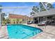 Sparkling pool in a screened-in lanai with lounge chairs, providing a relaxing outdoor space at 1245 Overland Dr, Spring Hill, FL 34608