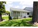 Exterior view with green grass, mature tree and view of screened porch at 12511 Dearborn Dr, Hudson, FL 34667