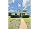 Charming home with well-maintained lawn, trimmed hedges, and a concrete walkway leading to the front door at 12511 Dearborn Dr, Hudson, FL 34667