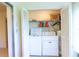 Convenient laundry closet featuring a washer, dryer, shelves, and standard white bi-fold doors at 12511 Dearborn Dr, Hudson, FL 34667