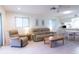 Bright living room featuring tile floors, comfortable seating, ceiling fan and abundant natural light at 12511 Dearborn Dr, Hudson, FL 34667