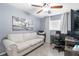 Comfortable bedroom featuring a ceiling fan, a sofa, and a home office setup at 13372 Dewey Ct, Spring Hill, FL 34609