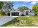 Charming single-story home boasts a three-car garage, arched entryway, and well-manicured landscaping at 13372 Dewey Ct, Spring Hill, FL 34609