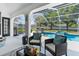 Covered patio with seating, a grill, and views of the pool and yard at 13372 Dewey Ct, Spring Hill, FL 34609