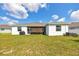 Spacious backyard with lush green grass and an inviting screened lanai at 13454 Golden Lime Ave, Spring Hill, FL 34609