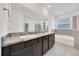 Bathroom featuring a double vanity with granite countertops and a soaking tub at 13454 Golden Lime Ave, Spring Hill, FL 34609