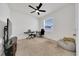 A carpeted bedroom with neutral paint, ceiling fan, and a large window with blinds at 13454 Golden Lime Ave, Spring Hill, FL 34609