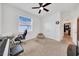 A carpeted bedroom featuring neutral paint, ceiling fan, and a large window with blinds at 13454 Golden Lime Ave, Spring Hill, FL 34609