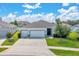 Charming single-story home featuring a two-car garage, lush landscaping, and a welcoming entrance at 13454 Golden Lime Ave, Spring Hill, FL 34609