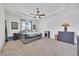 Bright main bedroom featuring a ceiling fan, bedside table, and decorative dresser at 13454 Golden Lime Ave, Spring Hill, FL 34609