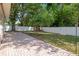 Private backyard featuring a brick patio, green lawn, and mature trees at 13923 Pathfinder Dr, Tampa, FL 33625