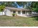 Spacious backyard with a patio, sunroom, and lush greenery, ideal for outdoor relaxation at 13923 Pathfinder Dr, Tampa, FL 33625