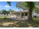 Backyard featuring a patio, sunroom, hot tub, and mature trees under a bright sky at 13923 Pathfinder Dr, Tampa, FL 33625