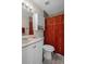 Well-lit bathroom with white vanity, storage cabinet, and decorative red shower curtain at 13923 Pathfinder Dr, Tampa, FL 33625