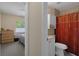 Bedroom featuring a laundry hamper and a doorway that leads to a red-themed bathroom at 13923 Pathfinder Dr, Tampa, FL 33625