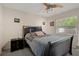 Cozy bedroom features a ceiling fan, natural light from a window, and a dark wood bed frame at 13923 Pathfinder Dr, Tampa, FL 33625