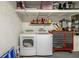 Garage with laundry machines, overhead storage, and a rolling toolbox at 13923 Pathfinder Dr, Tampa, FL 33625