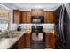Functional kitchen with wood cabinets, black appliances, and ample counter space at 13923 Pathfinder Dr, Tampa, FL 33625